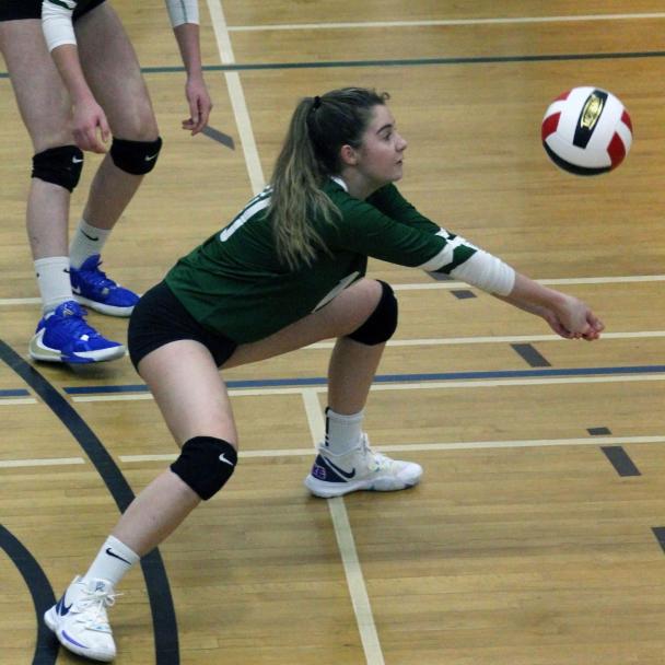 A girl preparing to hit a falling volleyball